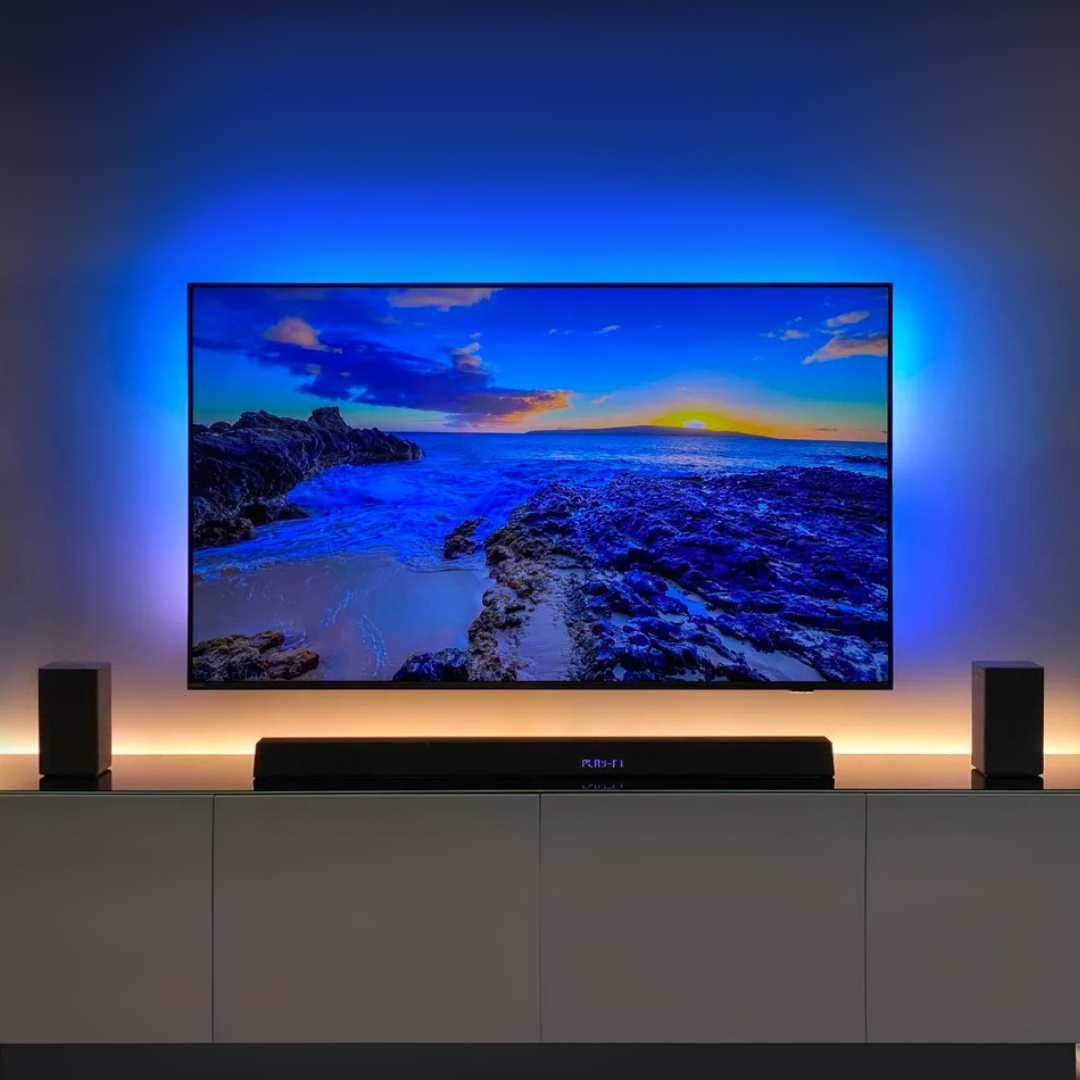 Mounted televsision with ambient light behind it and a soundbar system